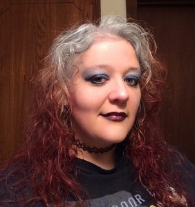 A picture of Molly Burkhart with red hair, looking very punk rock